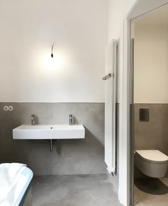 Neues Bad der Stadtvilla R mit wandhängendem Waschtisch, fugenloser Wandgestaltung und Zugang zum Schlafbereich